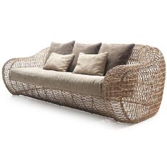 a wicker couch with four pillows on it's back and two side by side