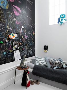 a bedroom with chalkboard walls and furniture