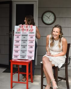 a woman sitting on a chair in front of a clock