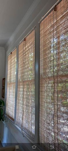 a living room filled with furniture and windows covered in blinds on the side of it