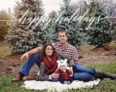 a man and woman sitting on the ground with a teddy bear in front of them