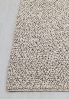 a white rug with small balls on it