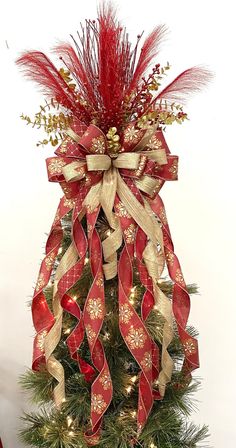 a christmas tree decorated with red and gold ribbons