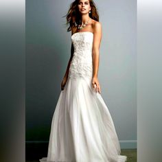 a woman in a white wedding dress posing for a photo with her hand on her hip