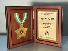 an award plaque with a star on it in a wooden box, which is displaying the medal for being awarded