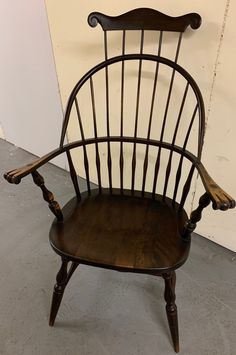 a wooden chair sitting in front of a white wall