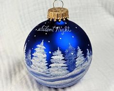 a blue christmas ornament with white trees and the words nelson night written on it