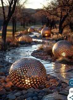 some very pretty looking lights on the rocks by the water with trees in the background