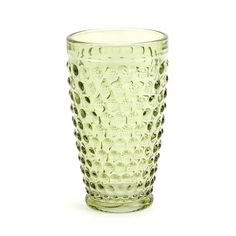 a green glass cup sitting on top of a white table