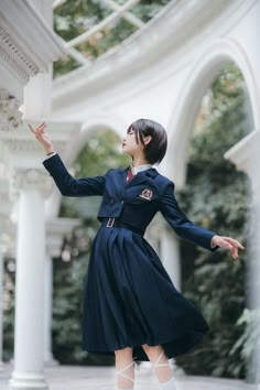 a woman in a blue dress and white shoes is standing on the ground with her arms outstretched