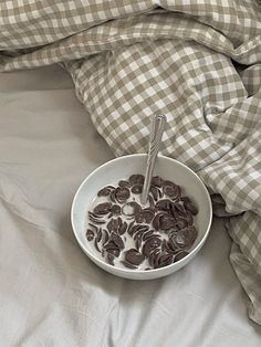 a bowl filled with chocolate chips on top of a bed