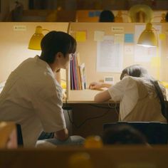 two people sitting at a desk in an office