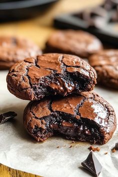 two chocolate cookies are stacked on top of each other and one is broken in half