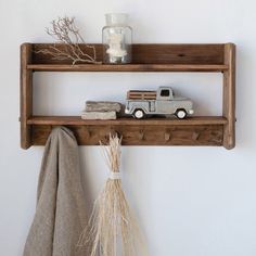 a shelf with a toy truck on top of it next to a towel and vase