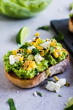 a piece of bread with guacamole and other toppings sitting on top of it