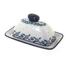 a blue and white dish with a black stone on top