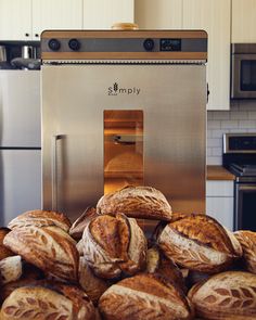 a pile of bread sitting on top of a counter next to a stove and oven