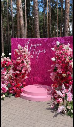 pink and white flowers on display in front of a sign