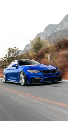 a blue bmw car driving down the road