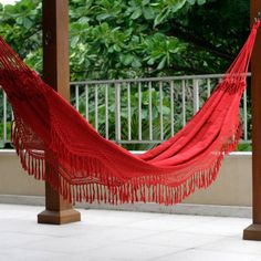 a red hammock hanging from a wooden structure