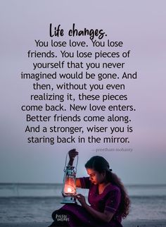 a woman sitting on the beach with a lantern in her hand and a quote about life changes