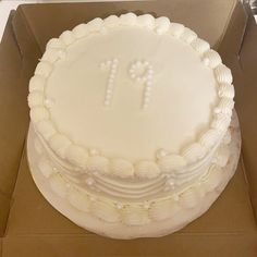 a white frosted cake in a box with the number 11 on it's side