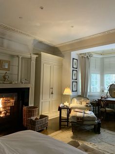 a living room filled with furniture and a fire place next to a window covered in curtains