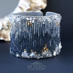 two silver and gold bracelets sitting next to each other on top of a table