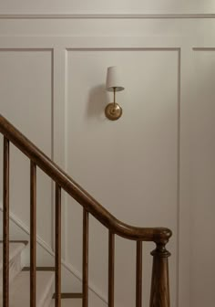 a light that is on the side of a stair case next to a banister