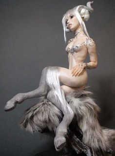 a statue of a woman sitting on top of a furry animal's back legs