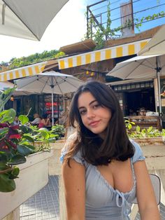 a woman is sitting at an outdoor table