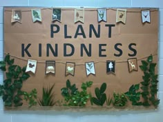 a bulletin board with plants on it that says plant kindness hanging from the wall