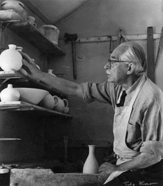 an old black and white photo of a man working on pottery