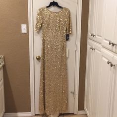 a gold sequin dress hanging on a door