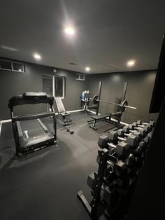 an empty gym room with equipment in the center and lights on above it, all lit up