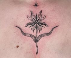 a close up of a person's chest with a flower tattoo on it