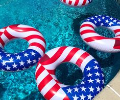 an inflatable swimming ring with american flags on it and two floats floating next to each other