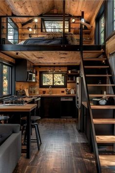 a loft style house with stairs leading up to the kitchen and living room in it