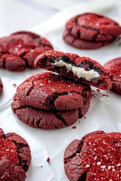 red velvet cookies with white icing and sprinkles are on a tray