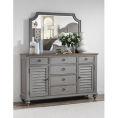 a gray dresser and mirror in a room