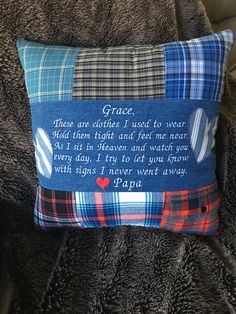 a pillow with a poem on it sitting on a couch next to a blanket and pillows