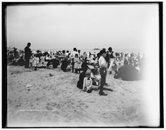 an old black and white photo of people on the beach