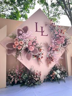 a floral display with the letter l on it's side and flowers in front