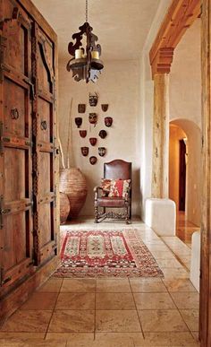 a hallway with wooden doors and rugs on the floor