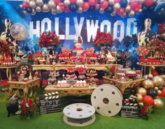 hollywood themed dessert table with red, gold and black decorations on the tables for an event