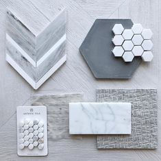 marble and tile samples are laid out on a table top, including hexagonal tiles