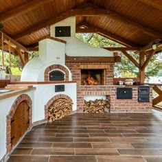 an outdoor kitchen with brick oven and wood flooring