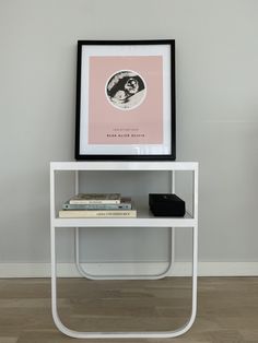 a white table topped with books and a framed photo