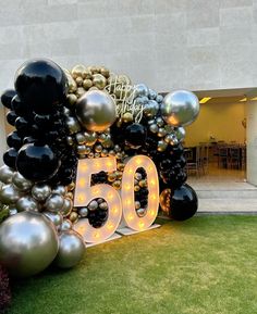 a large balloon arch with the number 50 displayed in front of it and balloons all around