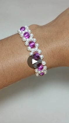 a woman's arm with a bracelet made out of pearls and amethyst beads